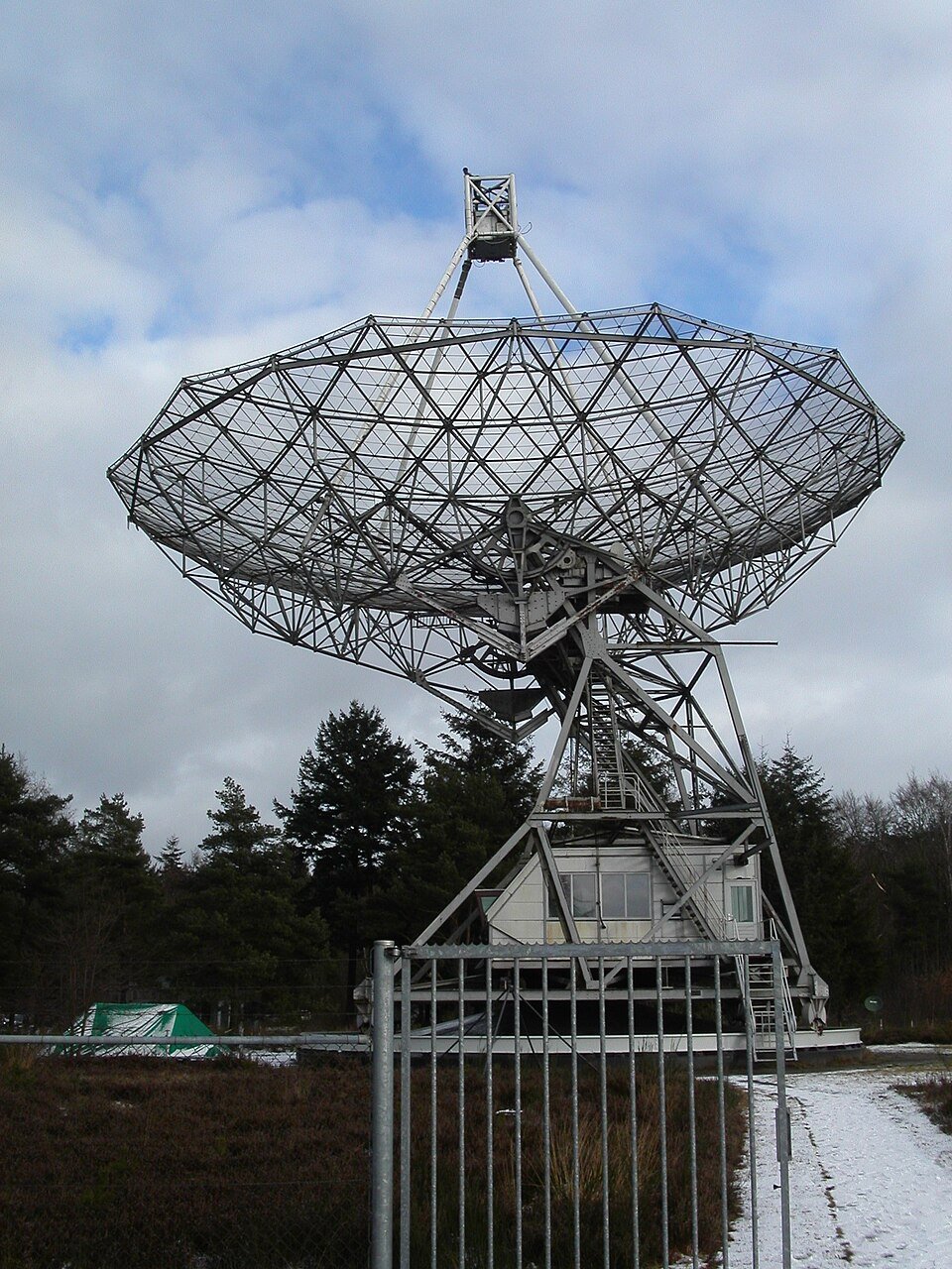 Dwingeloo radio telescope dish and support structure above trees on a winter day
